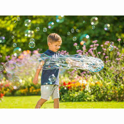 Enfant jouant avec des bulles géantes créées avec le set multi bulles