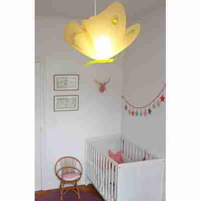 Suspension papillon jaune installée dans une chambre d’enfant