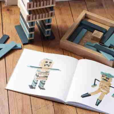 Livre Kapla ouvert présentant des personnages construits avec des planchettes colorées