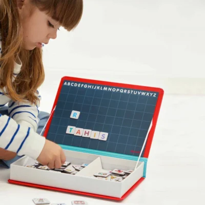 Enfant jouant avec les lettres magnétiques du Magnéti'book alphabet Janod