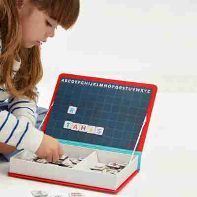 Enfant jouant avec les lettres magnétiques du Magnéti'book alphabet Janod