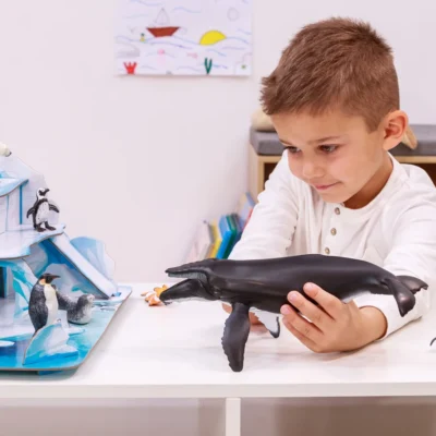 Enfant jouant avec la figurine Baleine à bosse Papo dans un univers marin