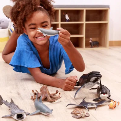 Enfant jouant avec la figurine Pieuvre Papo et différentes figurines d’animaux marins