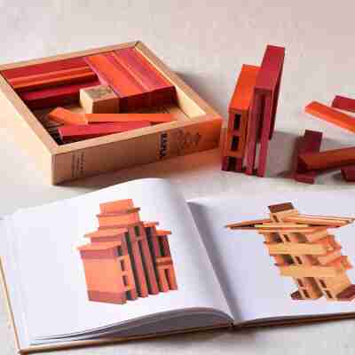 Livre Kapla ouvert avec modèles graphiques et construction en planchettes colorées