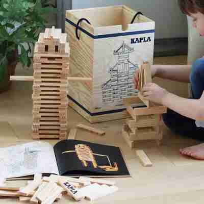 Enfant construisant avec des planchettes et le Livre d’art Kapla Animaux