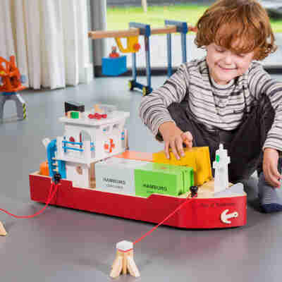 Enfant jouant avec le porte-conteneurs et les conteneurs New Classic Toys