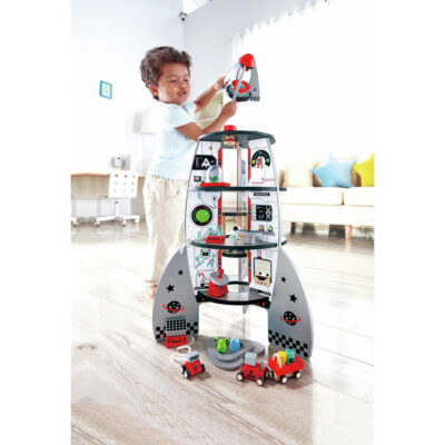 Enfant jouant avec la grande fusée spatiale en bois Hape dans sa chambre