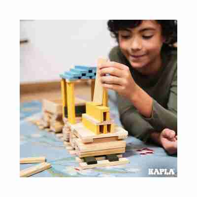 Enfant construisant avec les planchettes Kapla Nature et Couleur