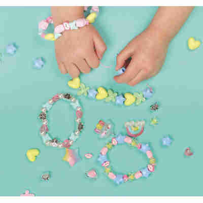 Enfant créant des bijoux avec les perles arc-en-ciel Auzou