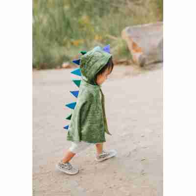 Enfant portant la cape de dragon verte Great Pretenders avec pointes dorsales bleues