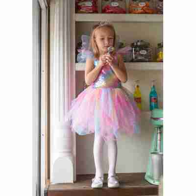 Enfant portant la robe et ailes de fée arc-en-ciel