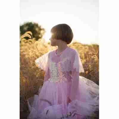 Enfant portant la robe rose Élégante Great Pretenders dans un champ au coucher du soleil