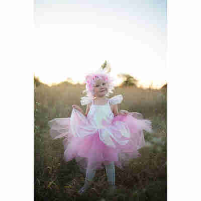 Enfant portant la robe de fée iridescente rose Great Pretenders dans un champ au coucher du soleil