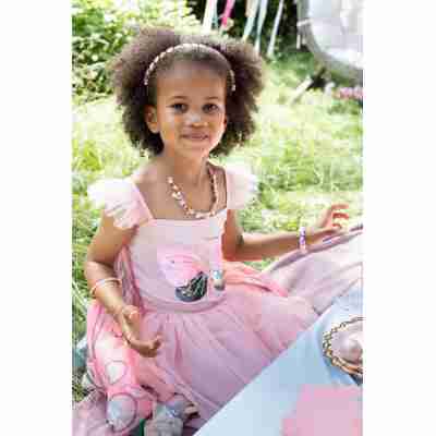 Enfant déguisé en papillon dans un jardin fleuri