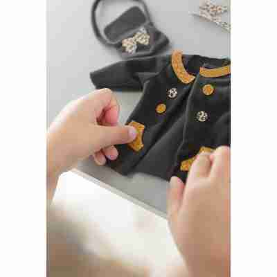 Enfant personnalisant le manteau de sa poupée Ma Chérie création