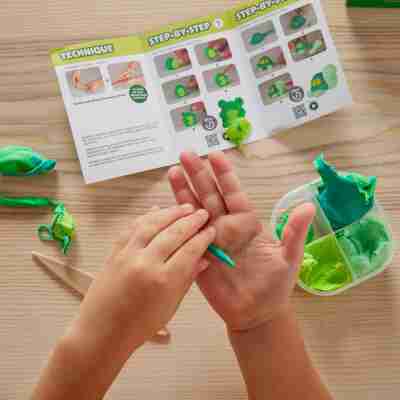 Enfant utilisant la pâte à modeler Super Clay Jungle avec guide illustré