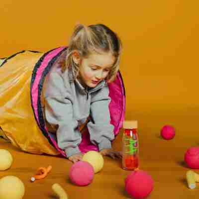 Enfant jouant avec une bouteille sensorielle Spiral Rose Petit Boum