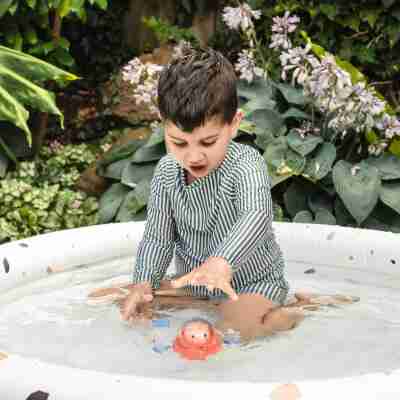 Enfant jouant avec le bateau Space Piggy dans une piscine