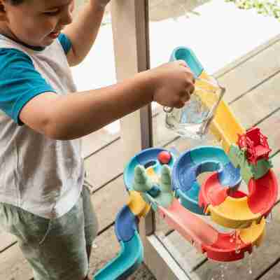 Enfant versant de l’eau dans le circuit Waterslide Marble Run Tiger Tribe