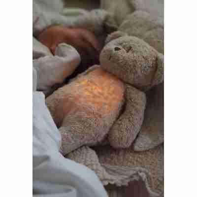Ourson Moonie Cappuccino lumineux près de bébé endormi