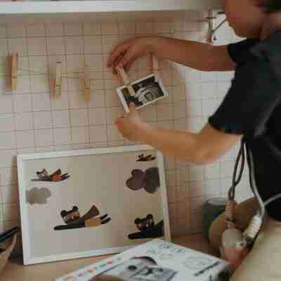 Enfant accrochant une photo imprimée avec KIDYPRINT