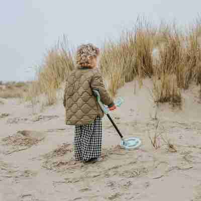 Enfant utilisant le détecteur de métaux Kidymetal sur la plage