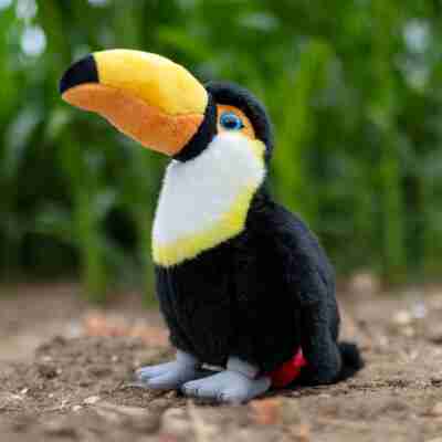 Peluche Toucan Animigos présentée dans un décor de forêt tropicale