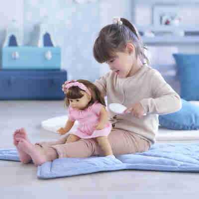 Enfant jouant avec le poupon Julie Corolle