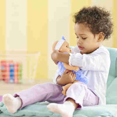 Enfant faisant un câlin au poupon Bébé Câlin Milly Corolle