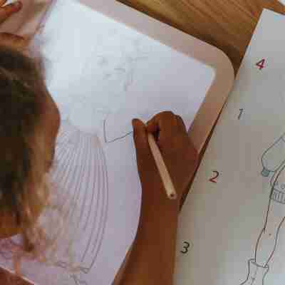 Enfant reproduisant un personnage de mode sur tablette lumineuse