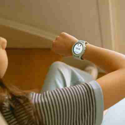 jeune utilisatrice consultant l'heure sur sa montre interactive verte