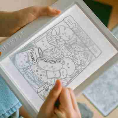 Enfant en train de décalquer une illustration sur la tablette lumineuse