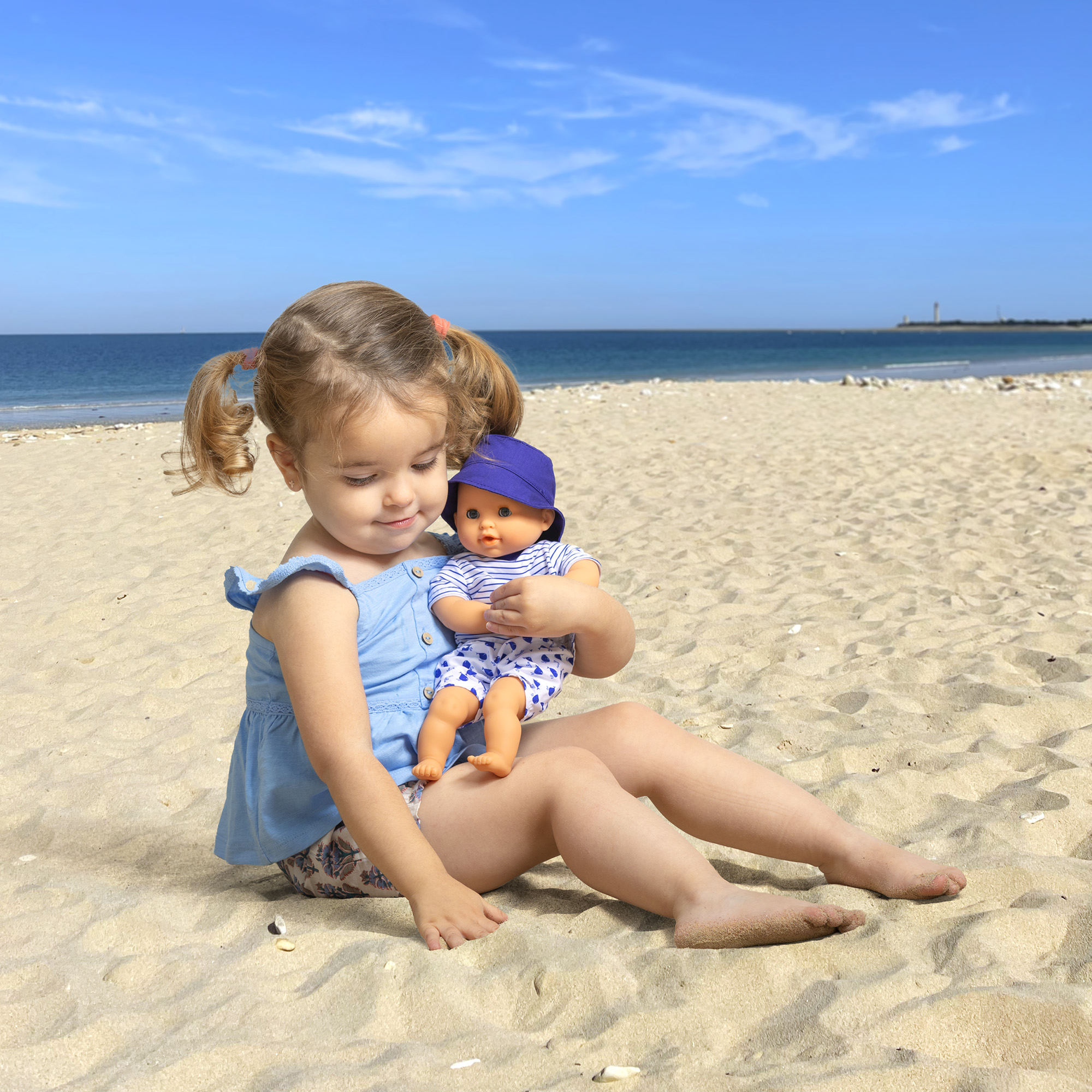 Poupon Bébé Bain - Marin 4 Enfant tenant le poupon Bébé Bain Marin Corolle sur la plage