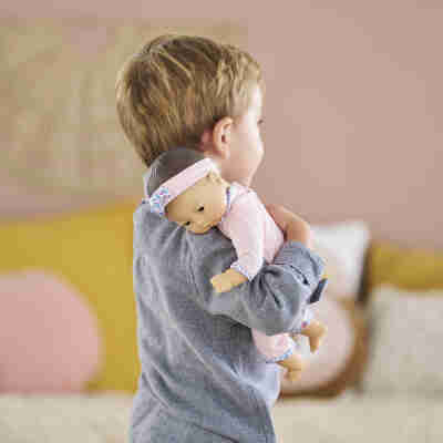 Bébé Câlin Mila Corolle blotti dans les bras d'un enfant