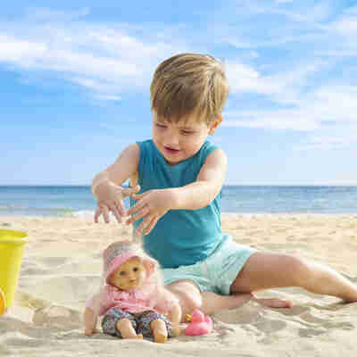 Bébé Bain Coralie Corolle dans un jeu de sable au bord de la mer