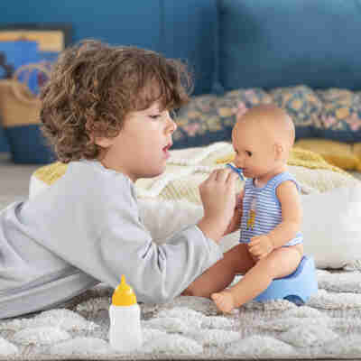 Enfant donnant la tétine au poupon Paul fait pipi Corolle
