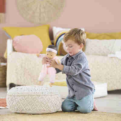 Enfant jouant avec le poupon Bébé Câlin Mila Corolle