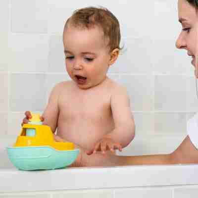Enfant jouant avec le bateau de Petit Renard dans la baignoire