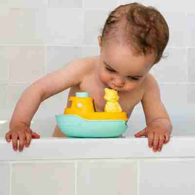 Enfant jouant avec le bateau de Petit Renard pendant le bain