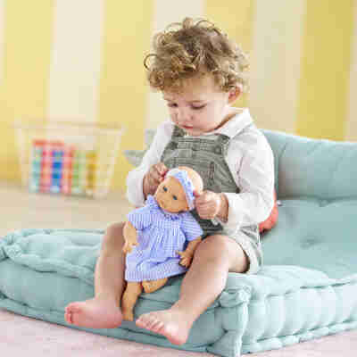 Enfant jouant avec le poupon Bébé Câlin Milly Corolle