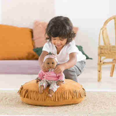Enfant jouant avec le poupon Bébé Câlin Maria Corolle