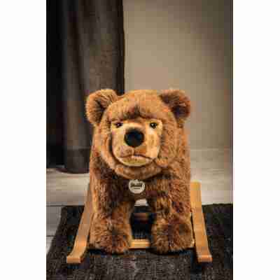 Urs l'ours brun à bascule Steiff vu de face dans une chambre d'enfant