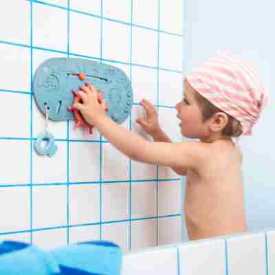 Enfant jouant avec le gouvernail du panneau de bain bateau pirate Lilliputiens