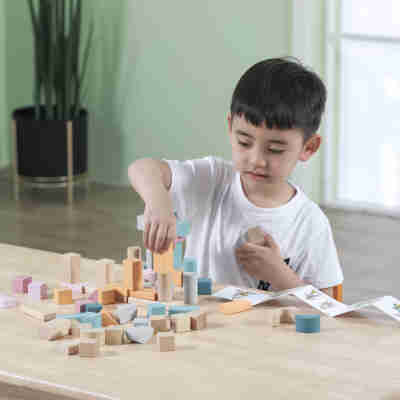 Enfant assemblant les blocs de construction en bois PolarB sur une table