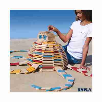 Enfant construisant une grande pieuvre avec des planchettes Kapla naturelles et colorées