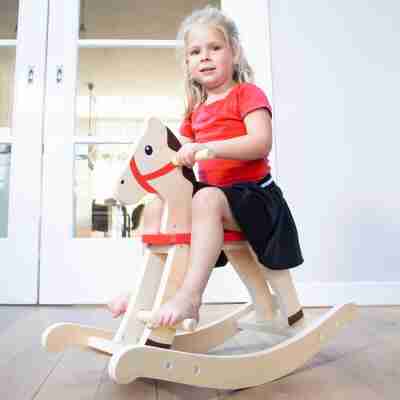 Enfant jouant sur le cheval à bascule en bois New Classic Toys