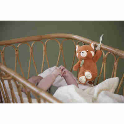 Peluche musicale panda roux Kaloo près de bébé au moment du coucher