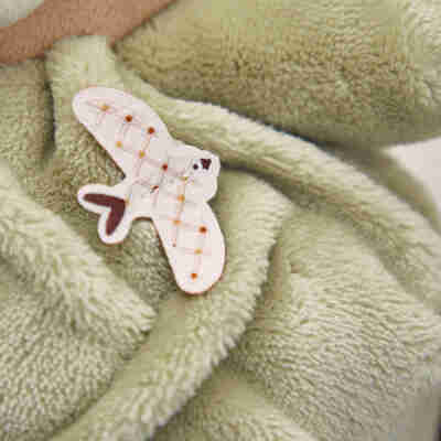 Détail de l’hirondelle décorative sur la peluche ours Patapouf Vert Kaloo