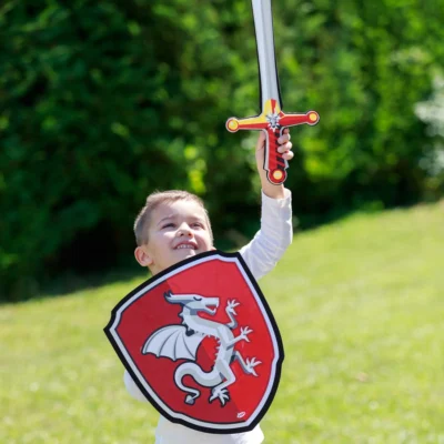Enfant jouant dehors avec l’épée et le bouclier Chevalier Dragon Papo