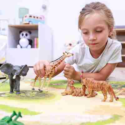Enfant jouant avec la tigresse et son bébé Papo parmi des figurines d’animaux sauvages